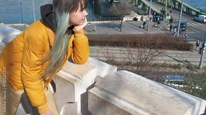 Enjoy city on budapest balcony. A thoughtful teen girl relax on balcony and enjoy the Budapest main street in the day light.