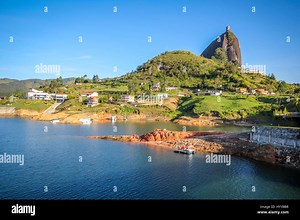 GUATAPE, COLOMBIA: COULD this rainbow-painted town be the most colourful place in the world? Stunning video and pictures have revealed the spectacular town where everything from the buildings to the steps are painted in bright, vibrant colours. The incredible images have a surreal feel as the multi-coloured houses stand in stark contrast to the aerial view of the lush green surrounding area. The snaps were taken in Guatapé, Colombia by Canadian photographer Jessica Devnani (27) from Toronto usin