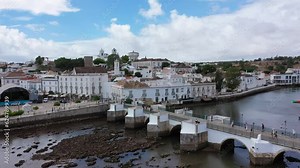 View on historic town of Tavira with Roman bridge over River Gilao, Algarve, Portugal. Cityscape of the Tavira old town with Clock tower, St Marys church, Algarve region, Portugal.