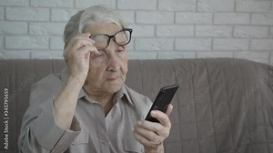 Elder with telephone problem. Old granny with a smartphone.