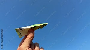 Euro note as paper airplane. 100 euros Banknote in form of paper plane. Money of European Union Euro note in hand on blue sky background. Concept of economy and banking. Euro Fall or rise of currency