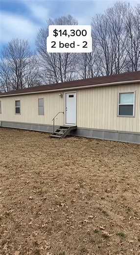 manufactured home priced at $14,300. From the outside, it looks simple and older, but it sits level and stable. Inside, the flooring feels firm and the layout offers balanced space for daily living. The kitchen is dated but fully functional with working plumbing. The split-bedroom layout provides added privacy, which is a strong feature at this price point. The master bedroom offers comfortable space, and having two bathrooms under $15k is rare in this range. For under $15k, this offers practica