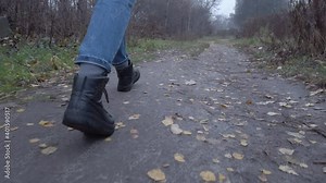 Wide view female legs walk through city park. Woman enjoying walking at the park, breathing fresh air.