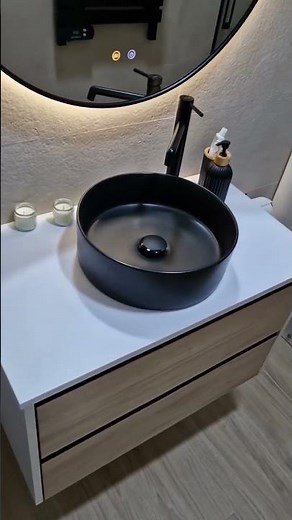 Mueble de baño suspendido lavabo sobre encimera negro mate y espejo redondo. Fabricación a medida