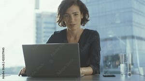 Confident Female Executive Works on a Laptop Sitting at Her Desk in Modern Office with Grandiose Cityscape View. Businesswoman Uses Laptop.
