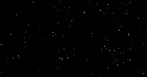 Seamless animated loop of snow particles slowly blowing on black background