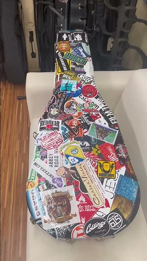 Famous guitar case with over 250 stickers. Adding a Collings Guitars sticker. ￼
