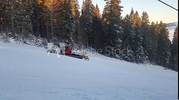 Snowplow machine working on the ski resort. Snow groomer preparing the ski slope.