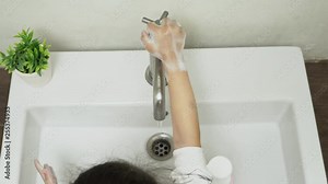 Little asian girl washing hands with soap under the faucet with water in the white bathroom and learning how to use the toilet by yourself, Teaching Your Child for Parents, KidsHealth Concept