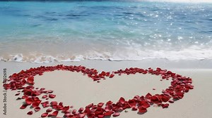 A delicate heart shape made from rose petals on a sandy beach, perfect for romantic occasions or as a symbol of love and affection.