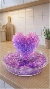 Ingredients 1 cup very hot water (just below boiling) 3 tablespoons borax powder (laundry aisle) Light purple food coloring (gel or liquid) Color Tip (Light Purple) Soft lavender: 1–2 drops purple Lilac tone: 1 drop purple 1 drop pink Very pale pastel: 1 drop purple 1 drop clear or white coloring Materials Light purple pipe cleaner White ceramic plate Small heatproof bowl or measuring cup Spoon Wooden skewer, pencil, or chopstick (optional, for support) Instructions 1. Shape the Heart Bend the l