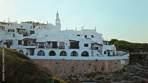 Binibeca Vell a Calm Cove Resort with narrow streets overlooking Mediterranean Sea in Menorca, Balearic Islands, Spain.. Binibeca Coastal Village with whitewashed houses with wooden windows and doors.