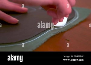 Closeup of a tailor marking fabric with chalk along a pattern before cutting. Sewing process, handmade clothing production