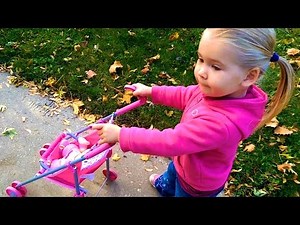 Cute Little Girl Pushing Baby Doll Stroller to Playground