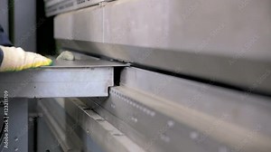 Worker hands bend metal sheet on a modern bending industrial machine at a factory. HD.