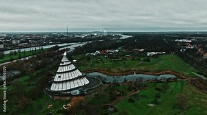 Drone shot of Millennium Tower (Jahrtausendturm) in Elbauen park near Elbe river, Magdeburg city. Cone-shaped structure with a viewing platform & exterior ramp plus science & technology exhibits.