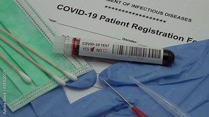 Diagnosis of coronavirus Covid-19 blood sample on rotating table with various medical equipment, including patient intake registration form of 'Department of Infectious Diseases'