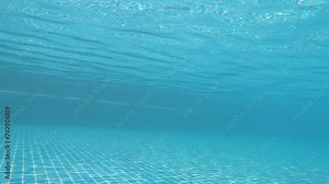 underwater view of outdoor swimming pool, the sun's ray pass through the water slow motion scene