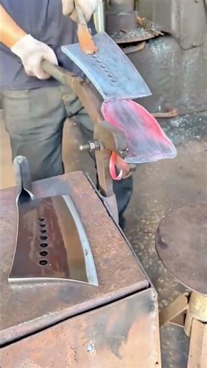 A blacksmith is using a tool to shape a glowing hot metal blade
