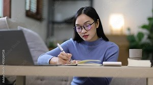 Young woman is writing income and expense records and financial statements at home. Personal financial planning and accounting.