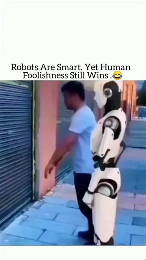 Fact Flick on Instagram: "This 14-second clip captures a surprisingly funny moment between a human and a humanoid robot in an urban alleyway. A man wearing a blue shirt repeatedly nudges a white humanoid robot against a closed metal shutter. Each time, the robot tries to respond logically—awkwardly pushing back, recalculating its balance, and attempting to stay upright—before eventually stumbling away in confusion. The moment is captioned to highlight how human unpredictability can still outsmar