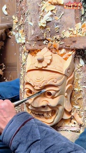 Skilled craftsman carving a face mask from small wood pieces