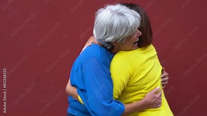 Senior women meeting and hugging each other in the city - Joyful elderly friendship concept