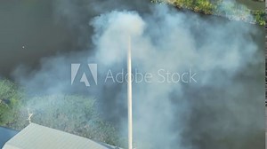 The white smoke, composed mainly of water vapor and trace pollutants, results from controlled combustion processes within the industrial plant. Health impacts and emissions concept. Aerial view drone