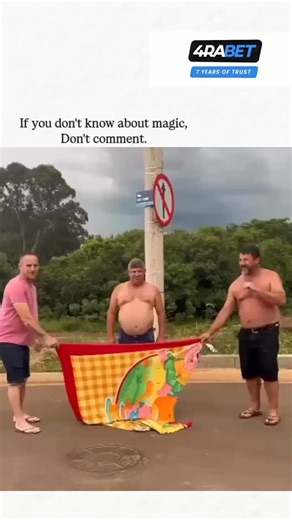 AalsiLaughs7 on Instagram: "This post features a 22-second video of a Brazilian street magic trick where three men hold a colorful beach towel in front of a lamppost, "disappearing" the middle man while his protruding belly creates a comical "pregnant lamppost" illusion, captioned sarcastically to deter uninformed comments. - Posted by @Rainmaker1973, known for curating awe-inspiring content on science and the unusual, the video exploded in popularity with 41k likes and 2.7 million views within 