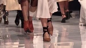 Female models walk the runway in beautiful colorful dresses during a Fashion Show. Fashion catwalk event showing new collection of clothes. Unrecognizable people. Legs and shoes only.