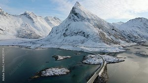 Aerial view over the Fredvang Bridge with Volandstind mountain in background, winter day in Flakstadoya, Lofoten Islands, Norway