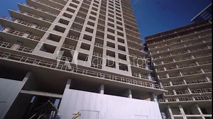 Crane and new multi-storey buildings. industrial basis. Work on construction site against blue sky. Bottom-up view of tall buildings. Work of developer or contractor. Stock Video