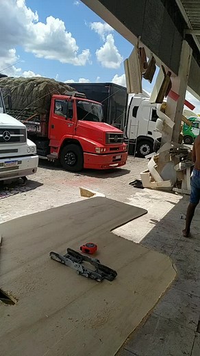 Outdoor Woodworking Process with Trucks in Background