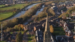 Sweeping aerial view of downtown Exeter, UK. A steeple of a church in the foreground, and the river Exe, the quay, and Exewick in the background