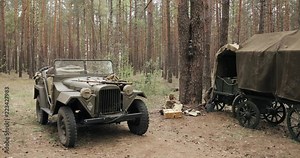 Russian Soviet World War II Four-wheel Drive Army Truck Gaz-67 Car And Peasant Carts In Forest. WWII Equipment Of Red Army