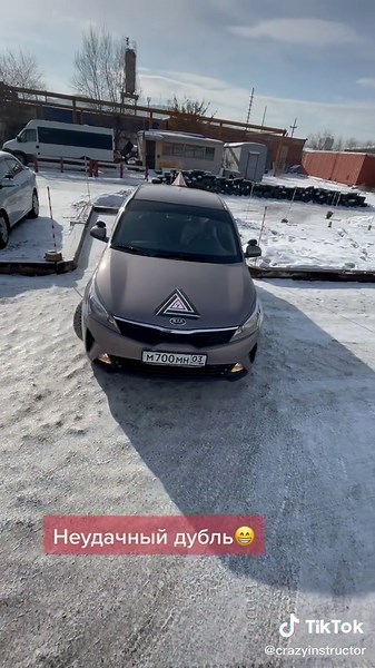 Brown Car with Triangular Logo in Snowy Parking Lot