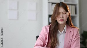 Serious businesswoman doing paperwork in the office is stressed due to excessive workload. Asian woman who is overworked, she is stressed and has a headache. Stock Video