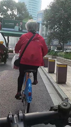 An elderly woman riding a bicycle