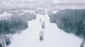 Cold winter day high up in mountains, Snowmass ski resort. Ski show great winter panorama 4K. Ski aerial of fast skiers in beautiful mountain forest landscape riding down snowy slope with high speed