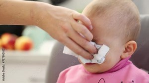 A little caucasian boy, one year old, sneezes and snot comes out of his nose. Colds and viruses in children. Flu and infections, close-up. Snot bubbles