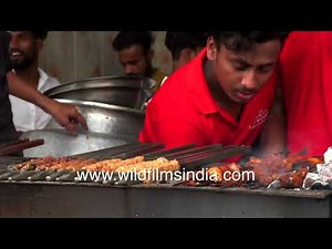 Seekh kabab on skewers being prepared on open fire spit in Jama Masjid