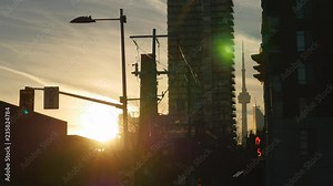 Golden sunset with silhouettes of streetlights and wires. Illuminated pedestrian warning hand counting down. Condos and CN tower in the background. Toronto, Canada. Stock Video