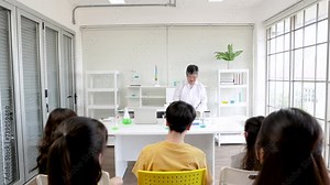 Senior science teacher guides a diverse group of students through experiments, encouraging collaborative learning experience in classroom, elderly instructor pensioner hiring in private school