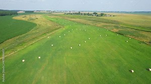 Haystack on field, drone view. Hay bale from residues grass. Hay stack for agriculture. Hay in rolls after combine harvester working in wheat field. Harvest season. Haystacks making.