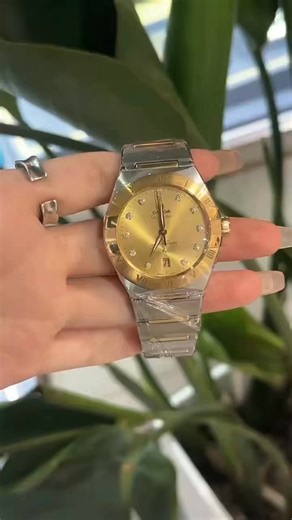 Chen Liying on Instagram: "The Omega Constellation Manhattan, 39mm two-tone model, features a champagne gold sunburst dial with diamond hour markers, a Roman numeral bezel, a date display at 6 o'clock, the 8800 Master Movement, and a transparent case back showcasing its luxurious design. #OmegaConstellation #ManhattanWatch #TwoToneLuxuryWatch #DiamondHourMarkWatch"
