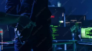 Dangerous computer hacker arrested by cyber security forces in the office at night. Close-up of hacker handcuffed against computer desk.