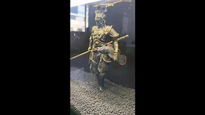 Pet fish poses under the arm of warrior statue in its tank