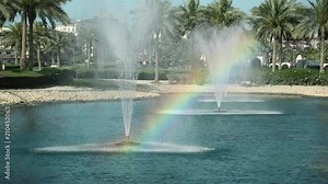 Fountains and colorful rainbow. Rainbow - meteorological phenomenon that is caused by reflection, refraction and dispersion of light in water droplets resulting in a spectrum of light appearing