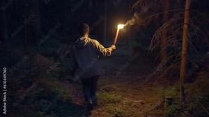 Mystical Spooky Scene of Fearless Young Woman Walking Alone in Woodland Nature Scenery Outdoors in Darkness
