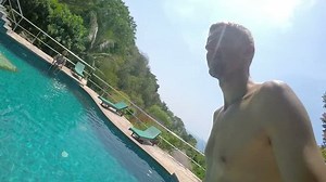 Young Man Dives Underwater with GoPro Taking Selfie in Pool.